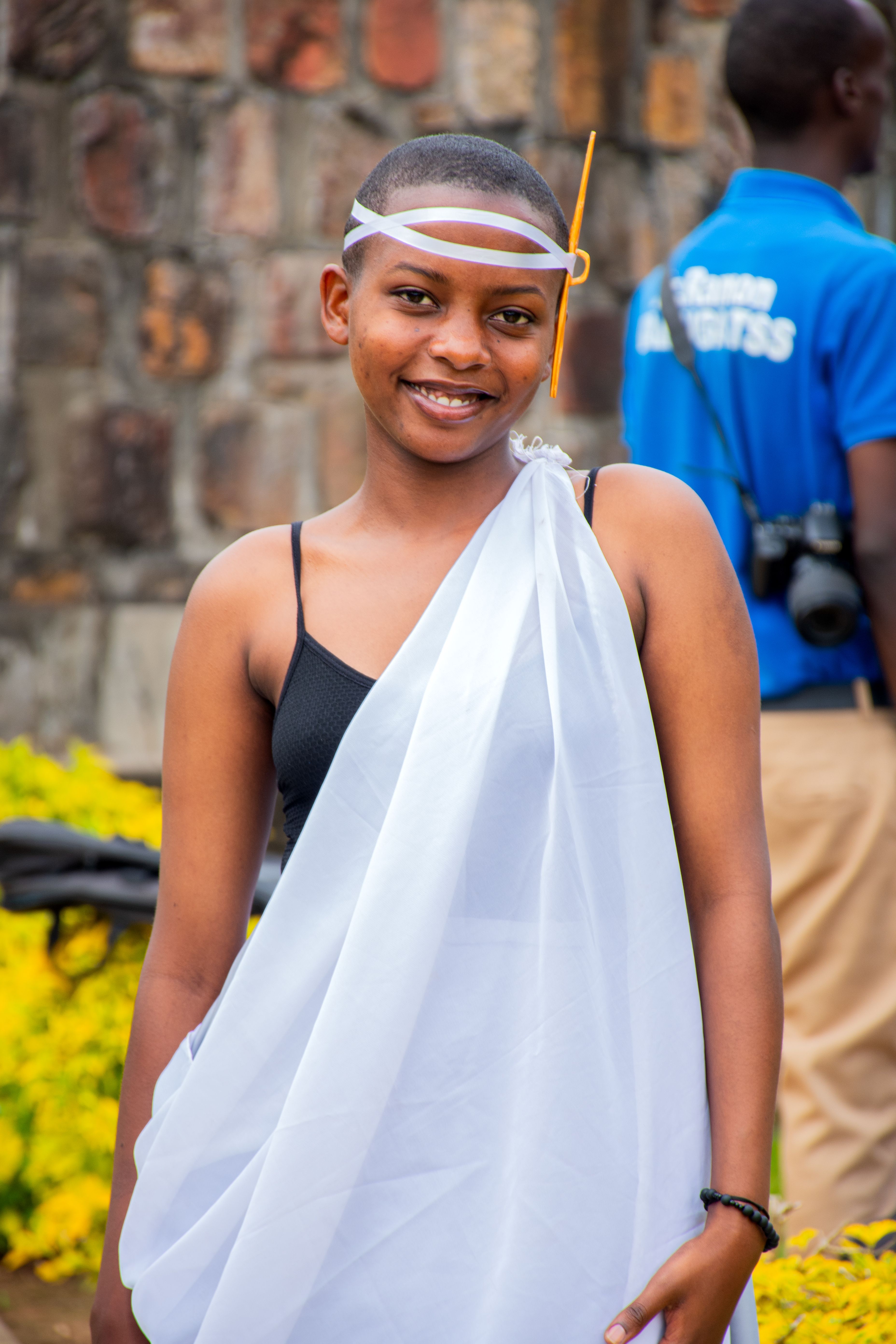 A learner in white attire standing outdoors